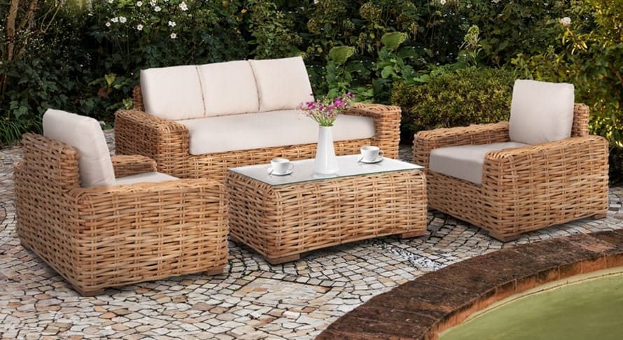 Έπιπλα κήπου τύπου wicker. Καναπές και πολυθρόνες κήπου ρατάν βρίσκονται μπροστά από φυτά.